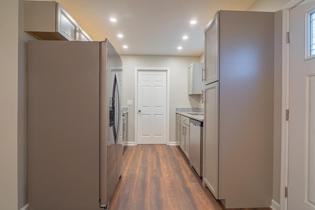 kitchen featuring light stone countertops, stainless steel appliances, and dark hardwood / wood-style floors