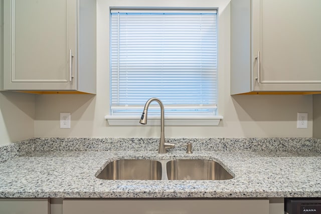 kitchen with sink and light stone counters