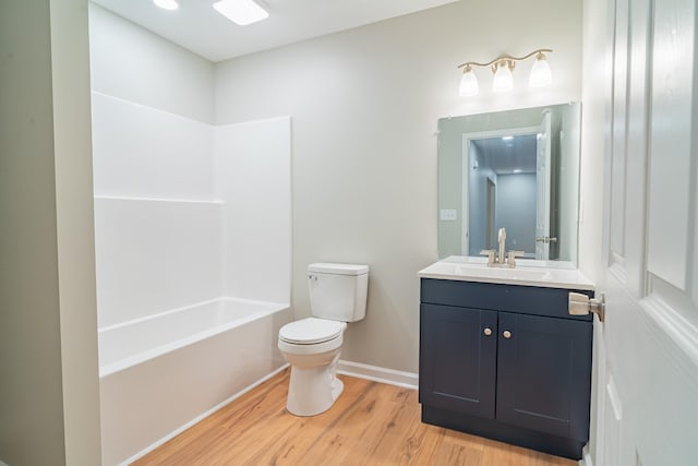 full bathroom featuring vanity, hardwood / wood-style flooring, toilet, and washtub / shower combination