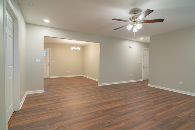 unfurnished room with dark hardwood / wood-style floors and ceiling fan with notable chandelier