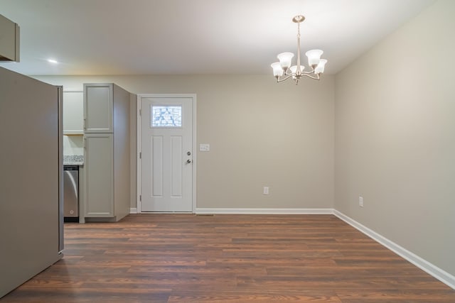 entrance foyer featuring an inviting chandelier and dark hardwood / wood-style flooring