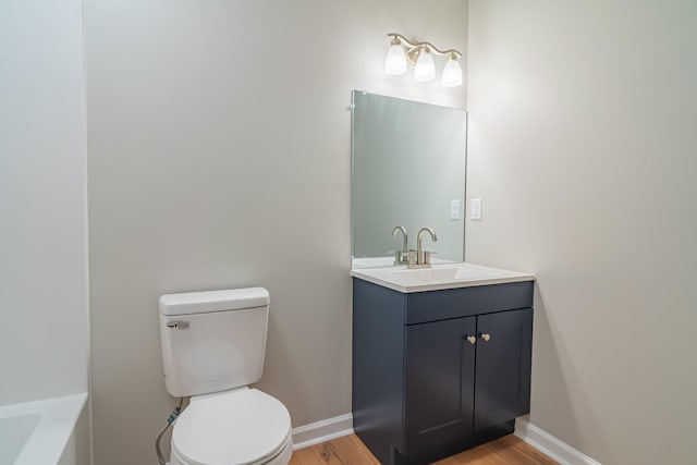 bathroom with vanity, hardwood / wood-style floors, and toilet