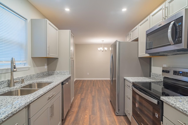 kitchen with sink, decorative light fixtures, stainless steel appliances, and light stone countertops