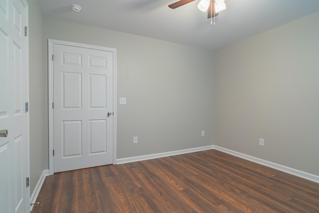 spare room with dark wood-type flooring and ceiling fan