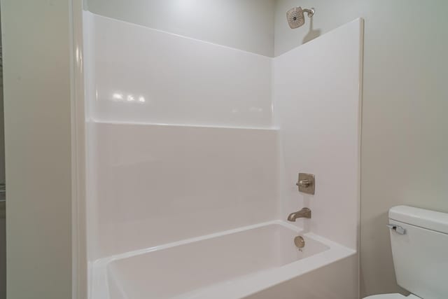 bathroom featuring shower / bath combination and toilet