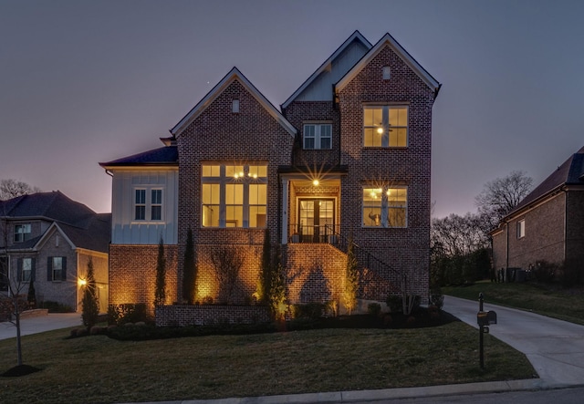 traditional home with a front lawn, concrete driveway, and brick siding