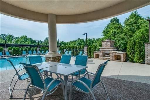 view of patio featuring exterior fireplace and a community pool