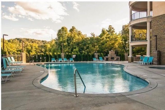 community pool featuring a patio and fence