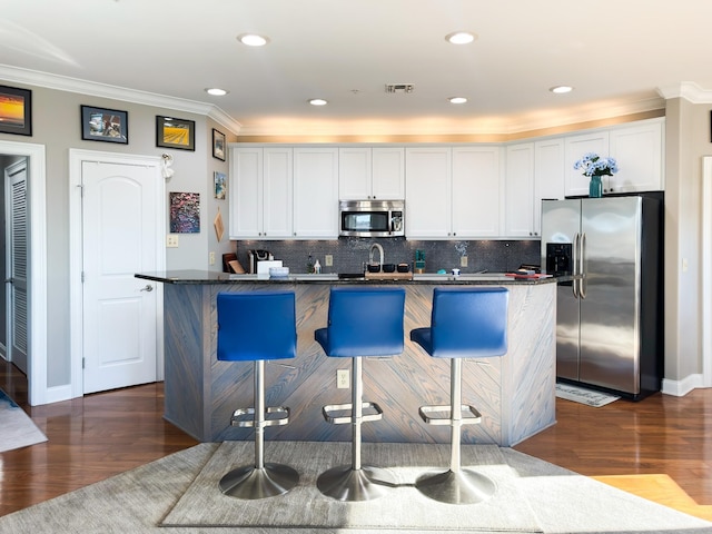 400 Warioto Way Unit 716, Ashland City, TN 37015 - kitchen featuring stainless steel appliances, crown molding, white cabinetry, a kitchen breakfast bar, and decorative backsplash