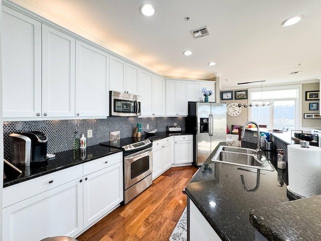 400 Warioto Way Unit 716, Ashland City, TN 37015 - kitchen featuring stainless steel appliances, a sink, wood finished floors, tasteful backsplash, and white cabinets