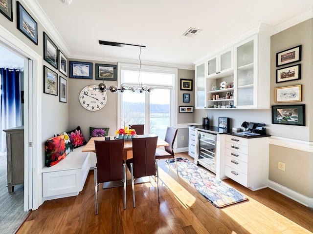 400 Warioto Way Unit 716, Ashland City, TN 37015 - dining space featuring beverage cooler, crown molding, dark wood finished floors, and baseboards