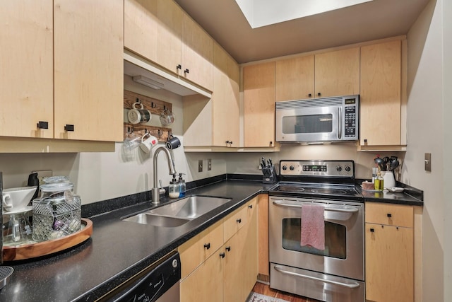 kitchen featuring stainless steel appliances, sink, and light brown cabinetry