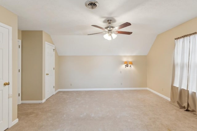 additional living space with lofted ceiling, light carpet, and ceiling fan