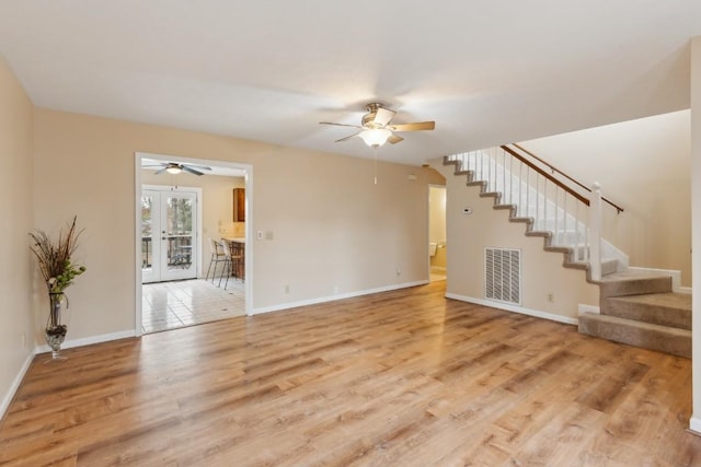 unfurnished living room featuring french doors, ceiling fan, and light hardwood / wood-style floors