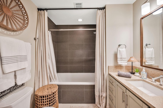 full bathroom featuring shower / tub combo with curtain, vanity, and toilet