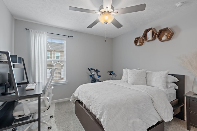 carpeted bedroom featuring ceiling fan and a textured ceiling