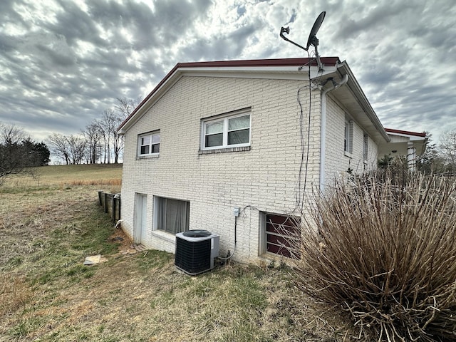 view of side of property with brick siding and cooling unit