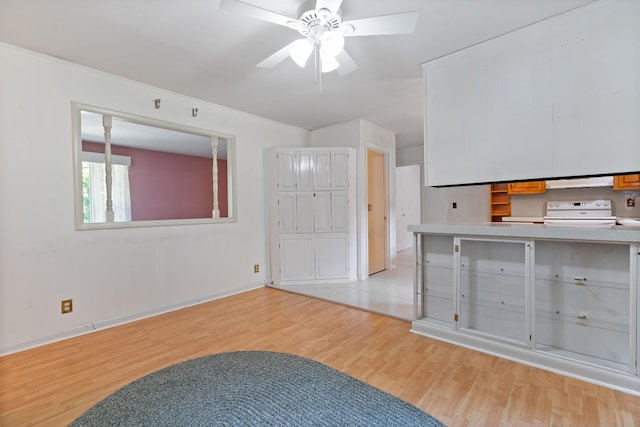 interior space featuring electric stove, light hardwood / wood-style flooring, and ceiling fan