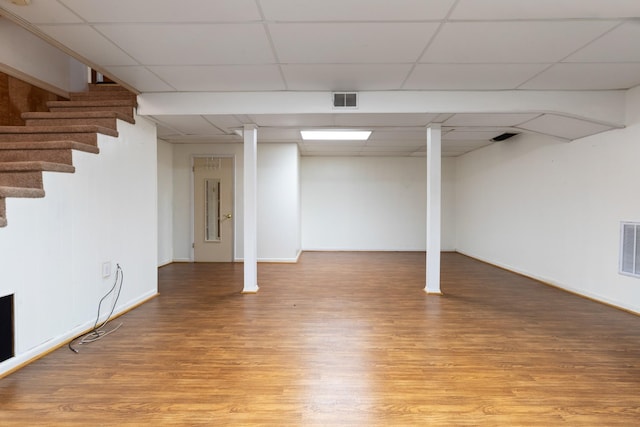 basement featuring a drop ceiling and wood-type flooring