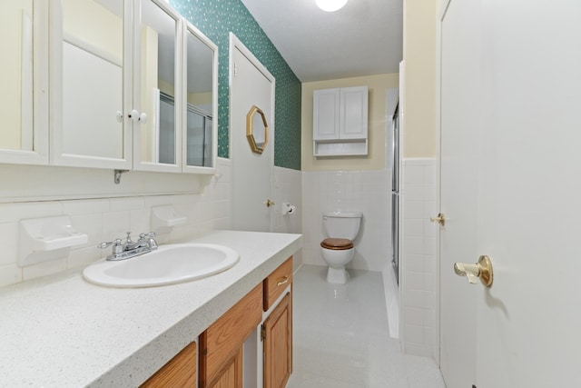 bathroom featuring vanity, tile walls, an enclosed shower, and toilet