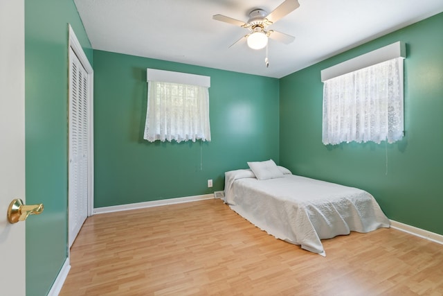 bedroom featuring light hardwood / wood-style flooring, a closet, and ceiling fan