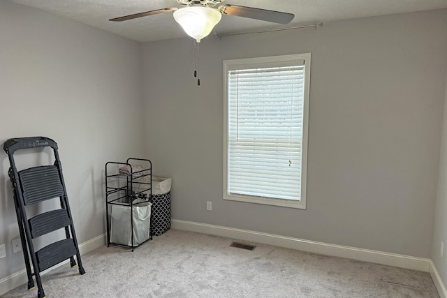 interior space with light carpet, a textured ceiling, and ceiling fan