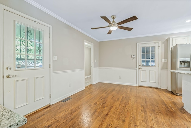 entrance foyer with crown molding, wood-type flooring, and ceiling fan