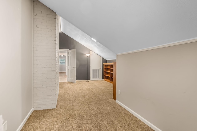 additional living space featuring vaulted ceiling and light colored carpet