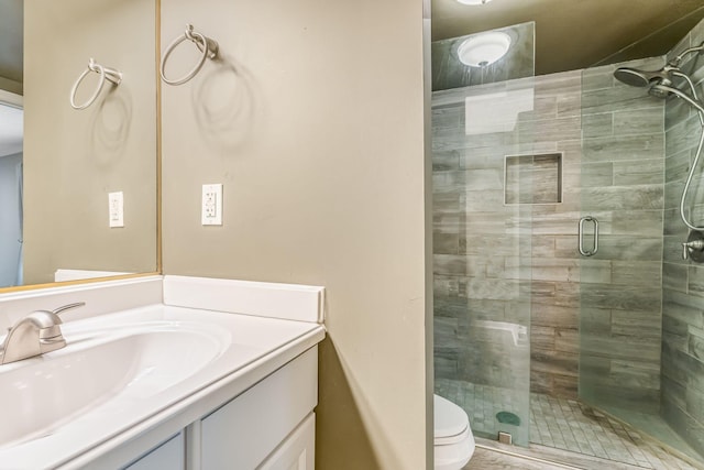 bathroom with vanity, toilet, and walk in shower