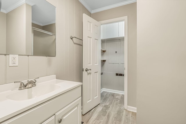 bathroom with vanity, crown molding, and hardwood / wood-style flooring