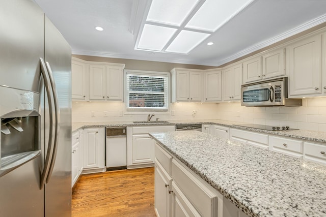 kitchen featuring light stone counters, sink, light hardwood / wood-style floors, and appliances with stainless steel finishes