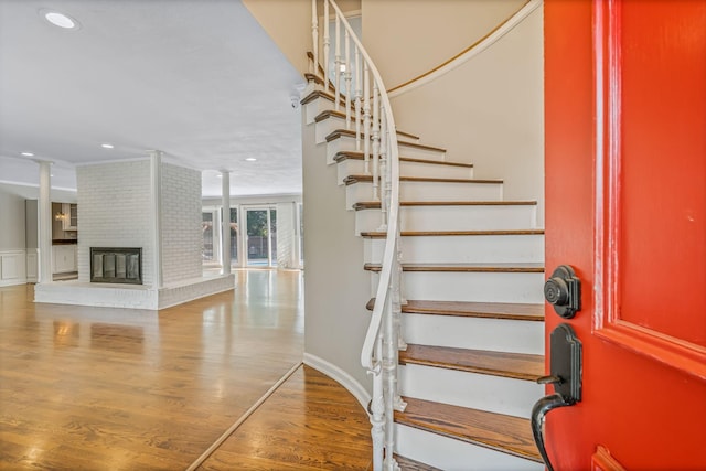 staircase featuring a fireplace and hardwood / wood-style floors