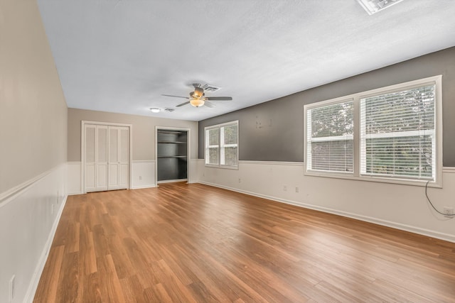 empty room featuring ceiling fan, wood-type flooring, and a textured ceiling