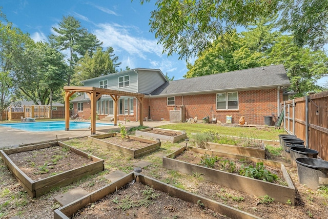 back of property with a fenced in pool