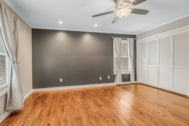 unfurnished bedroom featuring light hardwood / wood-style flooring, ornamental molding, a closet, and ceiling fan