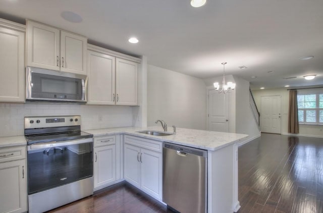 kitchen with sink, stainless steel appliances, kitchen peninsula, and white cabinets