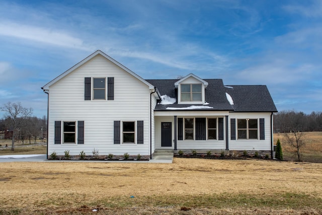 view of front facade with a front lawn and roof with shingles