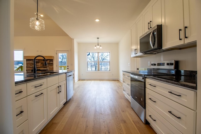 kitchen featuring light wood-style flooring, a sink, white cabinetry, and appliances with stainless steel finishes
