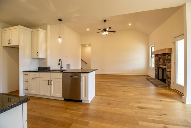 kitchen featuring stainless steel dishwasher, a sink, light wood-type flooring, ceiling fan, and white cabinetry