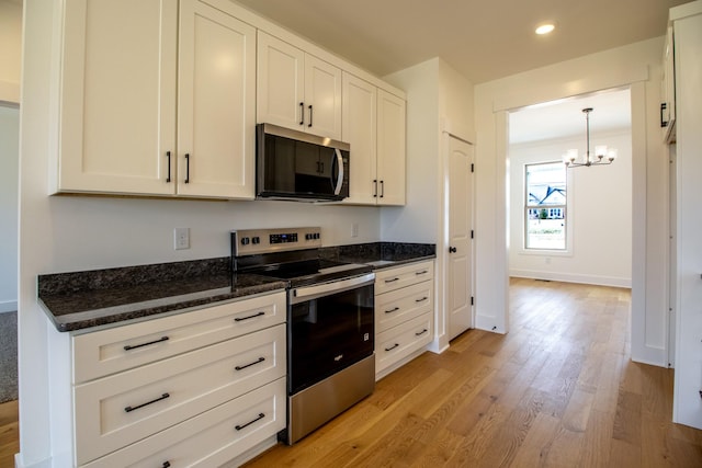 kitchen featuring electric range, a notable chandelier, light wood-style floors, and white cabinetry