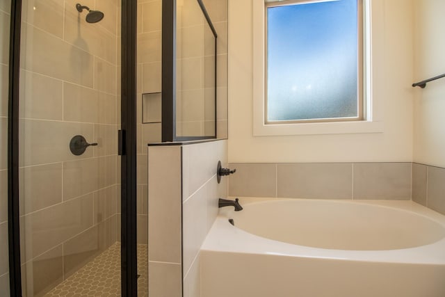 full bathroom featuring a wealth of natural light, a garden tub, and a stall shower