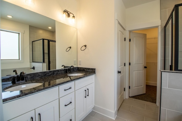 full bathroom featuring tile patterned flooring, a sink, a shower stall, and double vanity