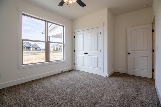 unfurnished bedroom featuring ceiling fan, carpet floors, a closet, and baseboards