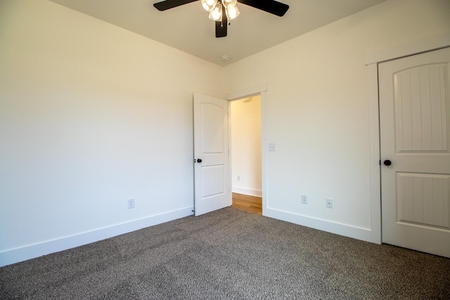 unfurnished bedroom with ceiling fan, carpet floors, and baseboards