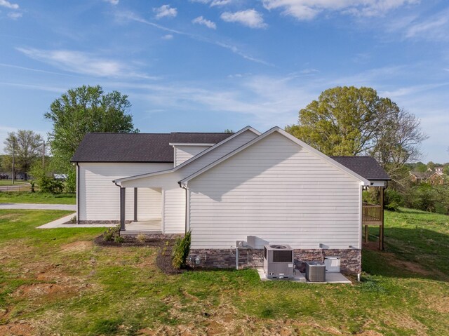 rear view of house with central air condition unit, a yard, and a patio