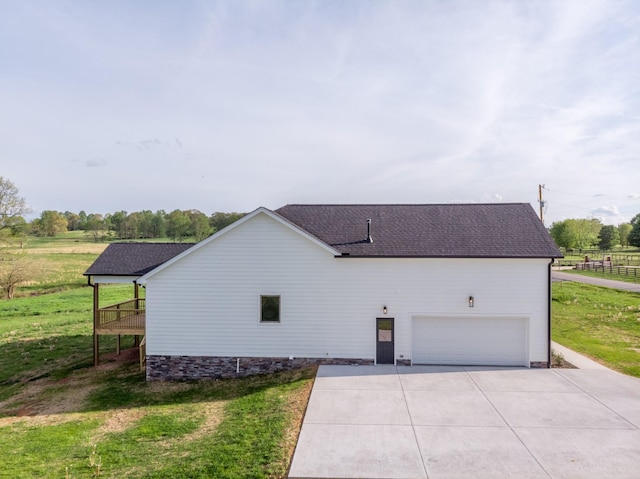 view of home's exterior featuring fence, a yard, an attached garage, driveway, and roof with shingles