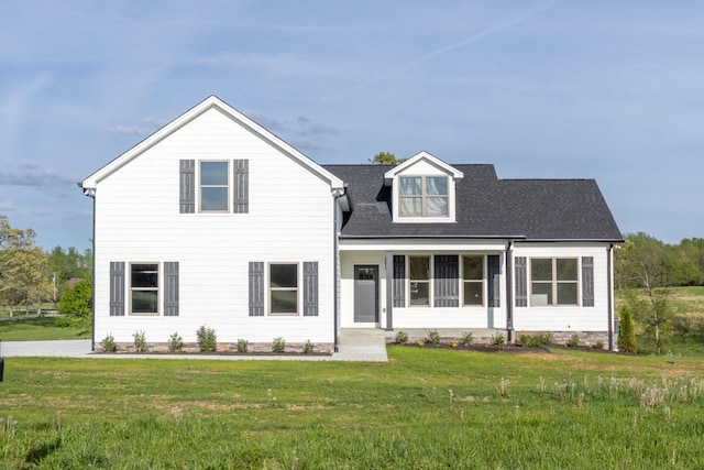 view of front of home featuring roof with shingles and a front yard