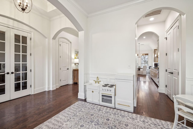 interior space with french doors, ornamental molding, and dark hardwood / wood-style floors