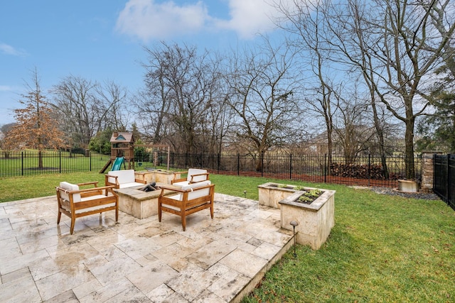 view of patio with a playground and a fire pit