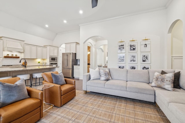 carpeted living room with crown molding and sink